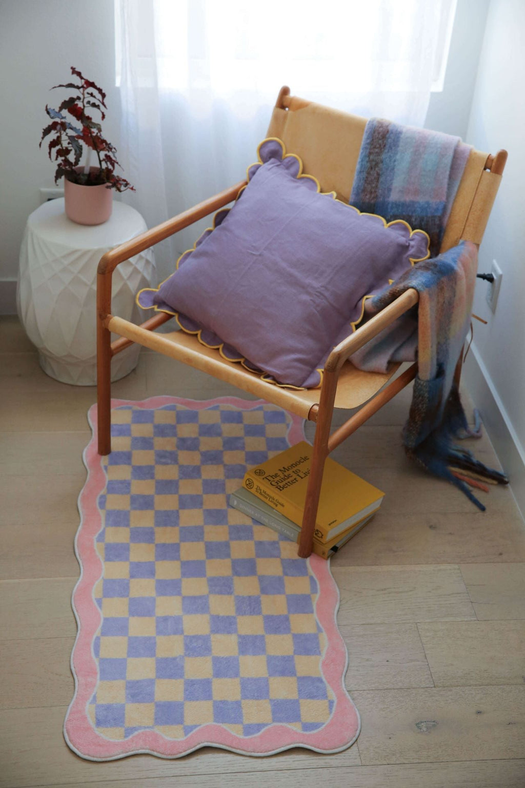 Pastel checkered runner beside a wooden chair with a lilac cushion, creating a cozy corner setup.