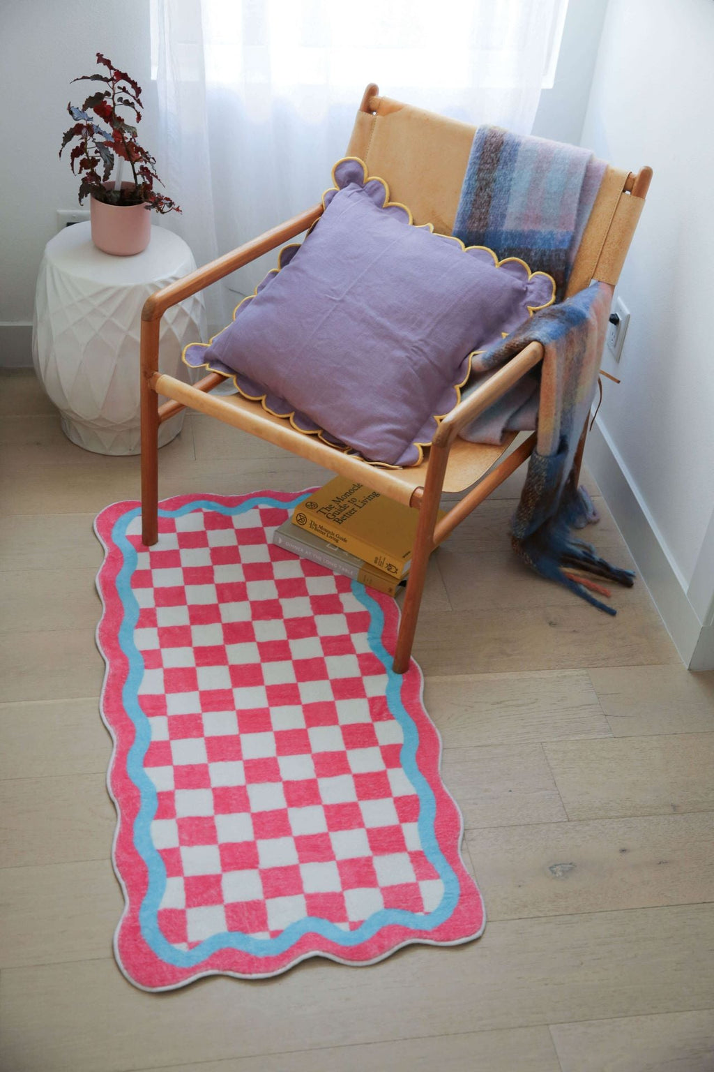 Pink and Blue Lace Checkerboard Runner under a wooden lounge chair with a scalloped lilac pillow and soft throw.