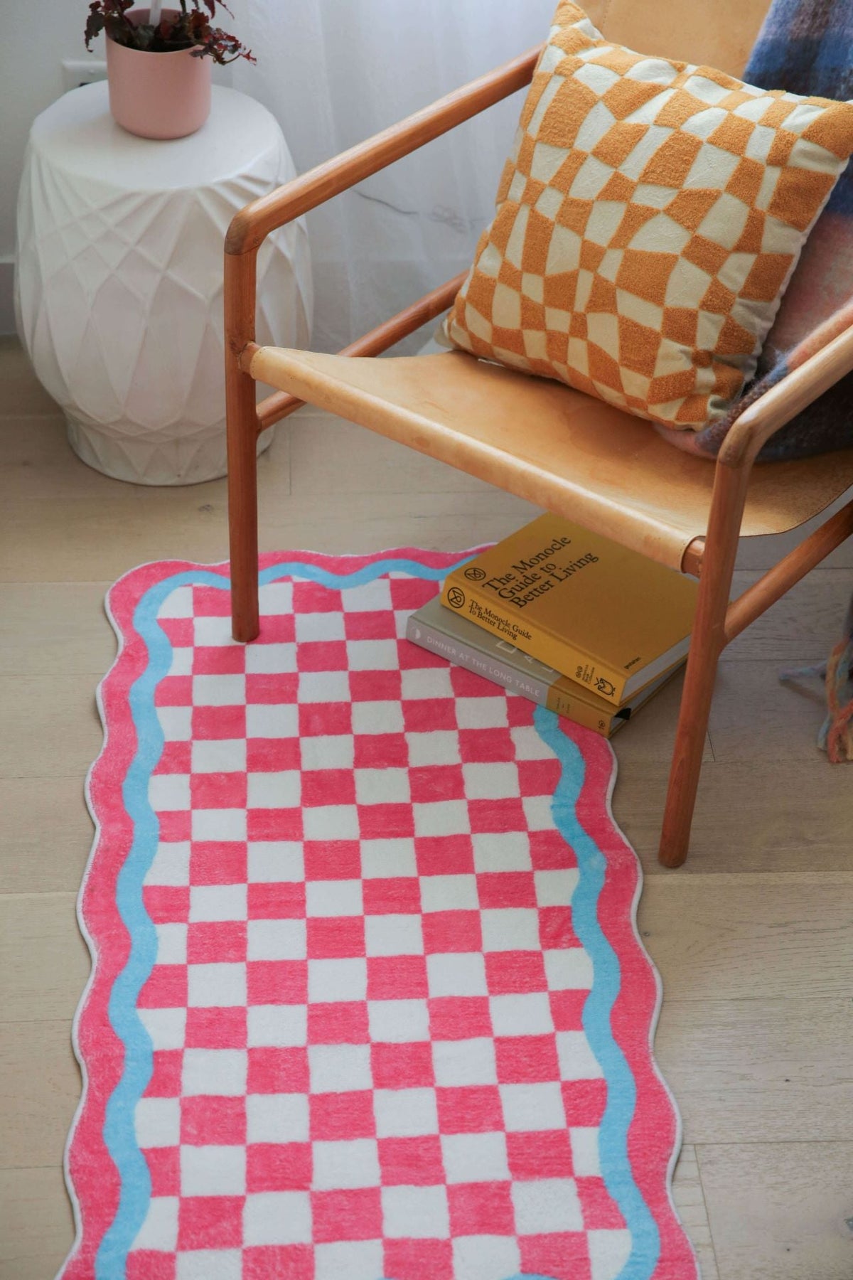 Close-up of the checkerboard runner paired with a wooden chair and orange checkered cushion.