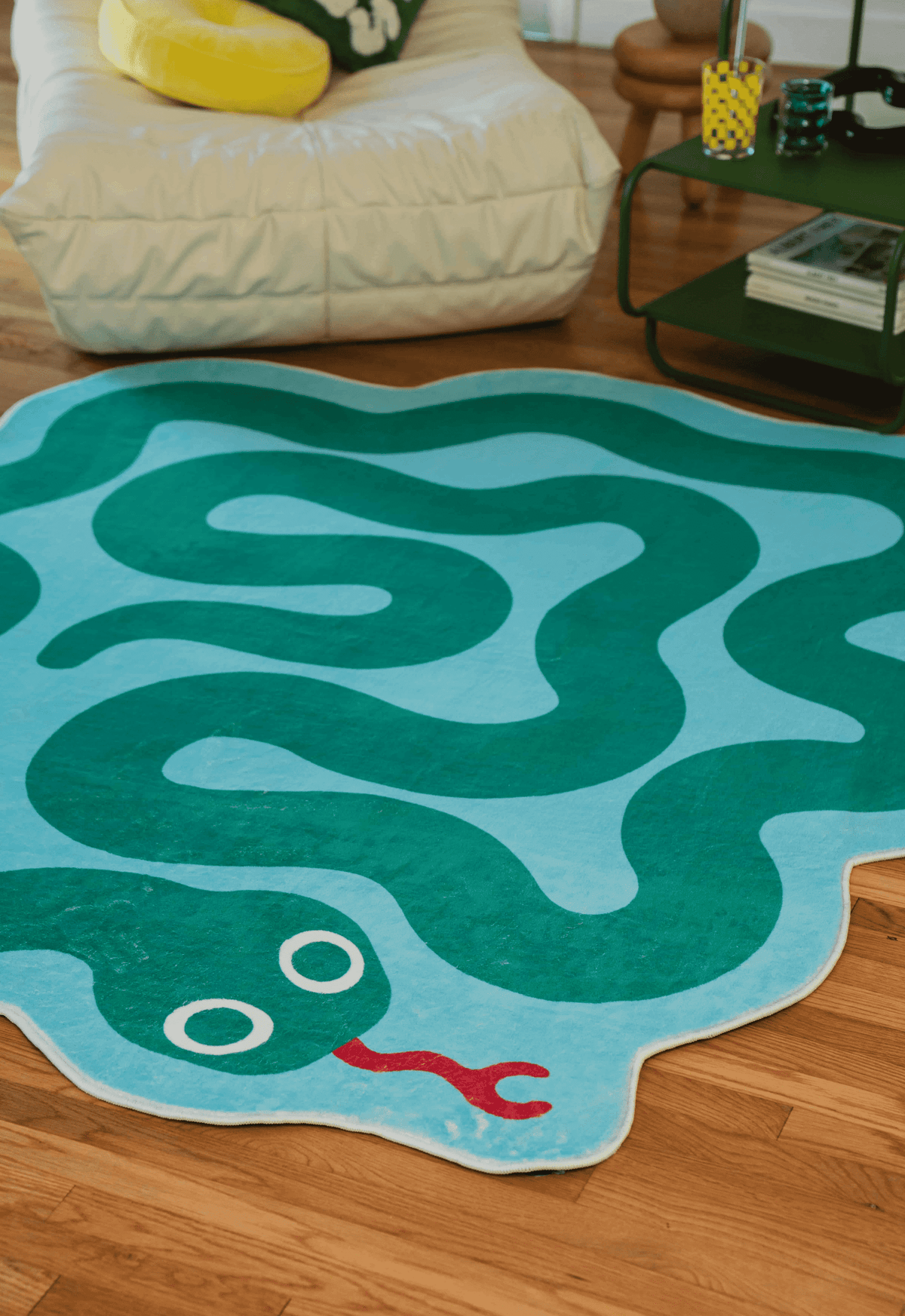 Close-up of the green and blue spiral snake rug in a cozy living room corner.