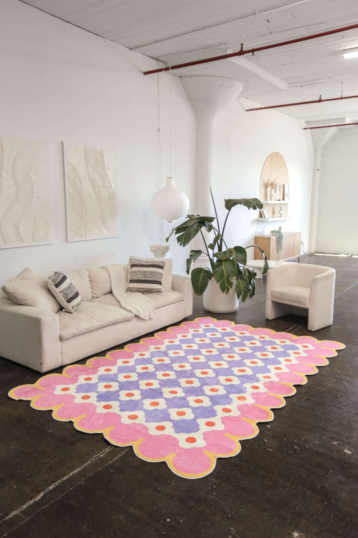 Floral rug styled in a high-ceiling loft with polished concrete floors and modern neutral furniture.