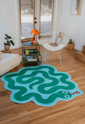 Spiral Snake Design Rug by Johann Banta styled in a cozy sunlit living room with white lounge seating and vibrant decor.