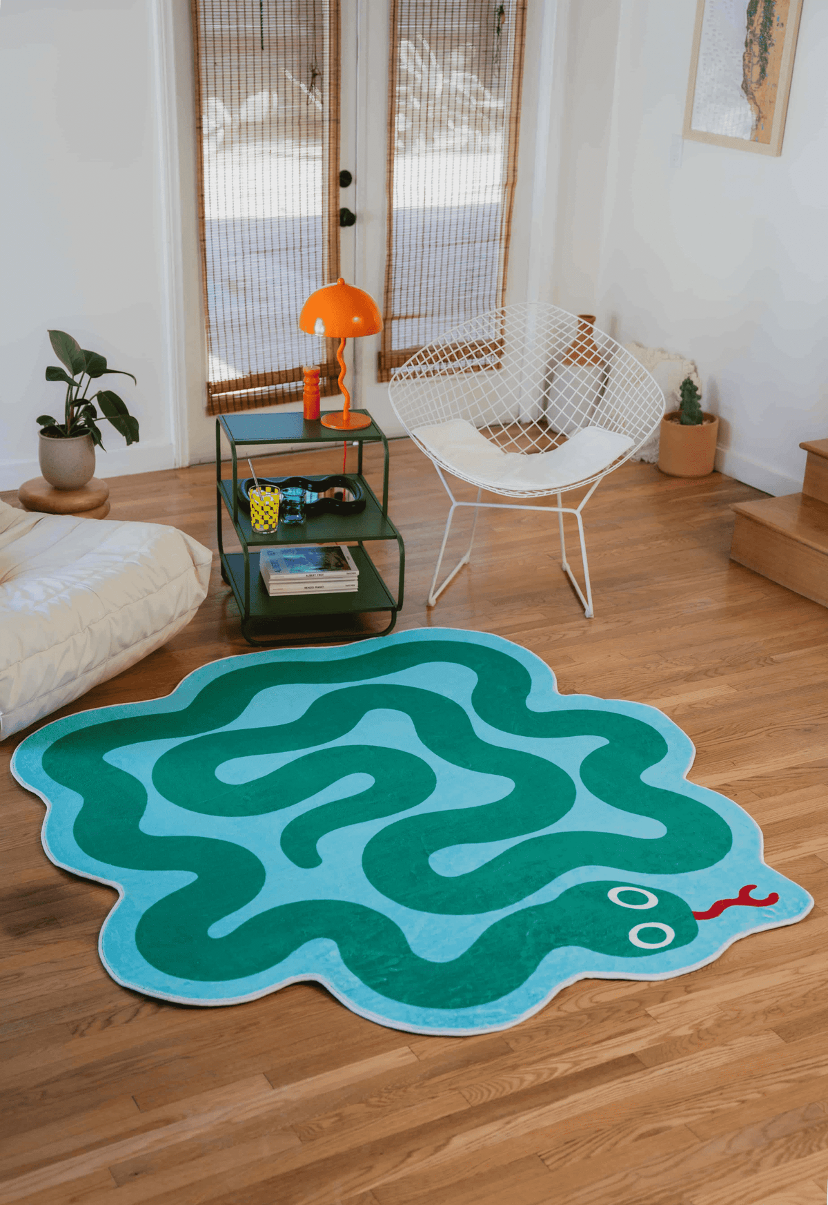 Spiral Snake Design Rug by Johann Banta styled in a cozy sunlit living room with white lounge seating and vibrant decor.