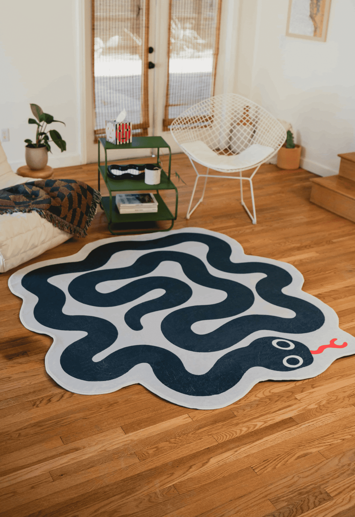 Navy and white spiral snake rug adds playful contrast to the bright wood floors and minimalist furniture.