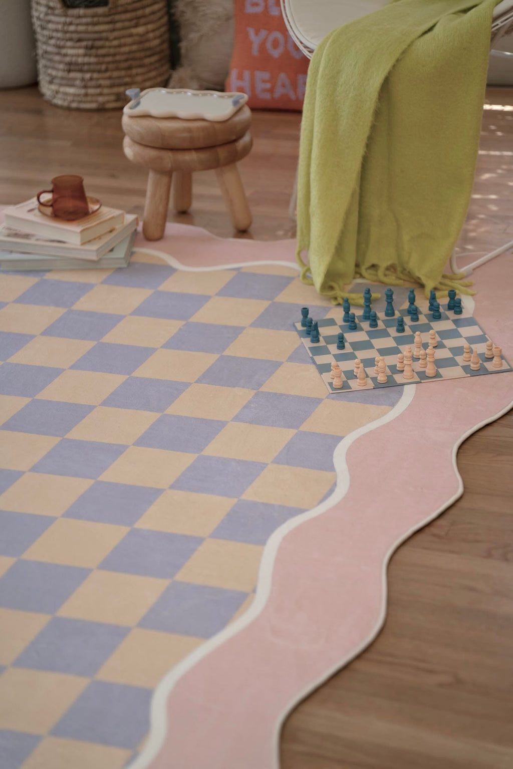 The pastel rug brings playful charm to the space, with a chess set and cozy seating completing the relaxed setting.