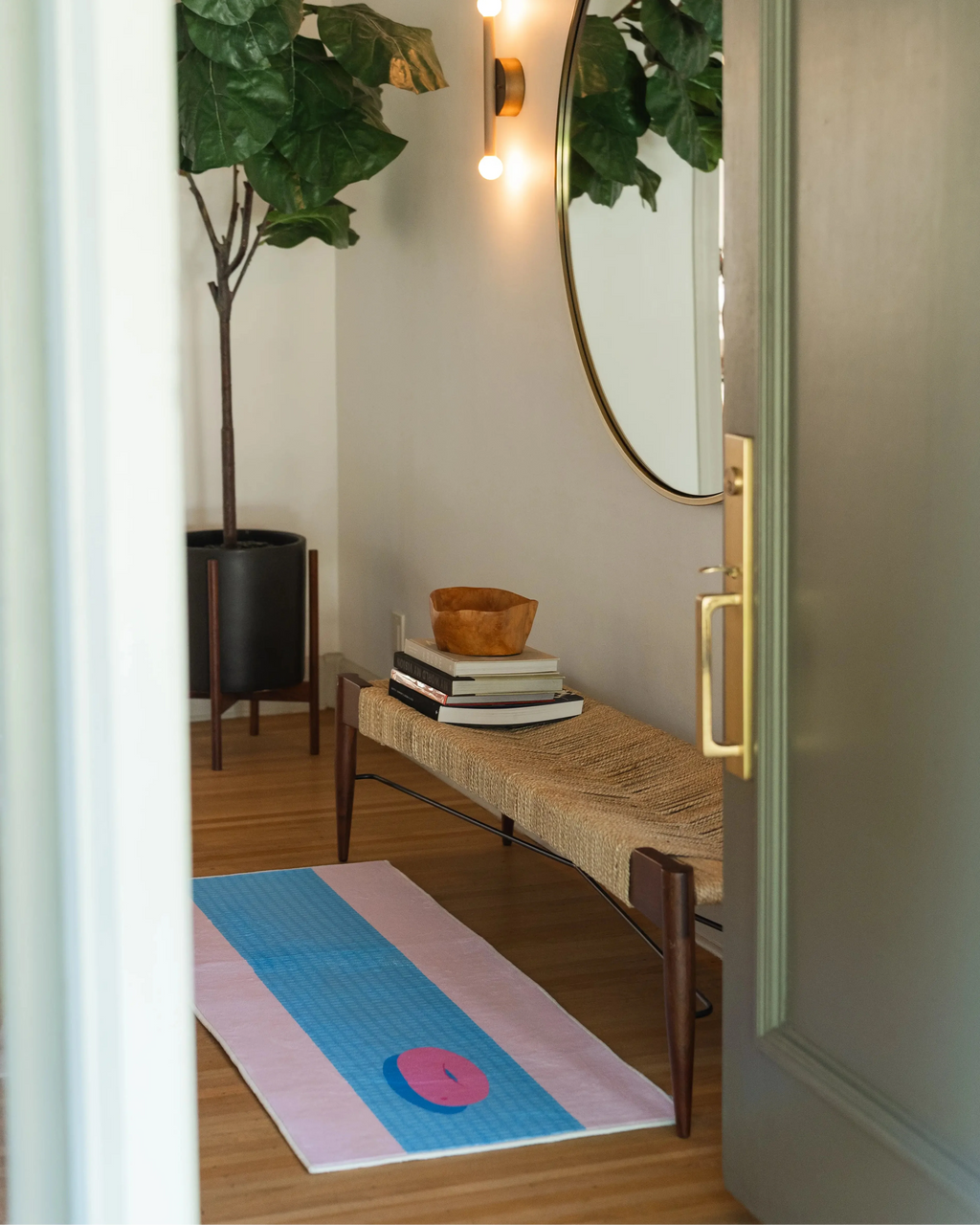 Pool runner rug viewed through a doorway, adding a playful blue and pink accent to a narrow entry space