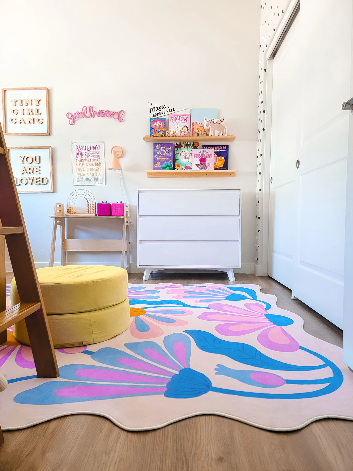 Purple floral wavy rug laid out in front of a white dresser in a kids’ bedroom with soft lighting.