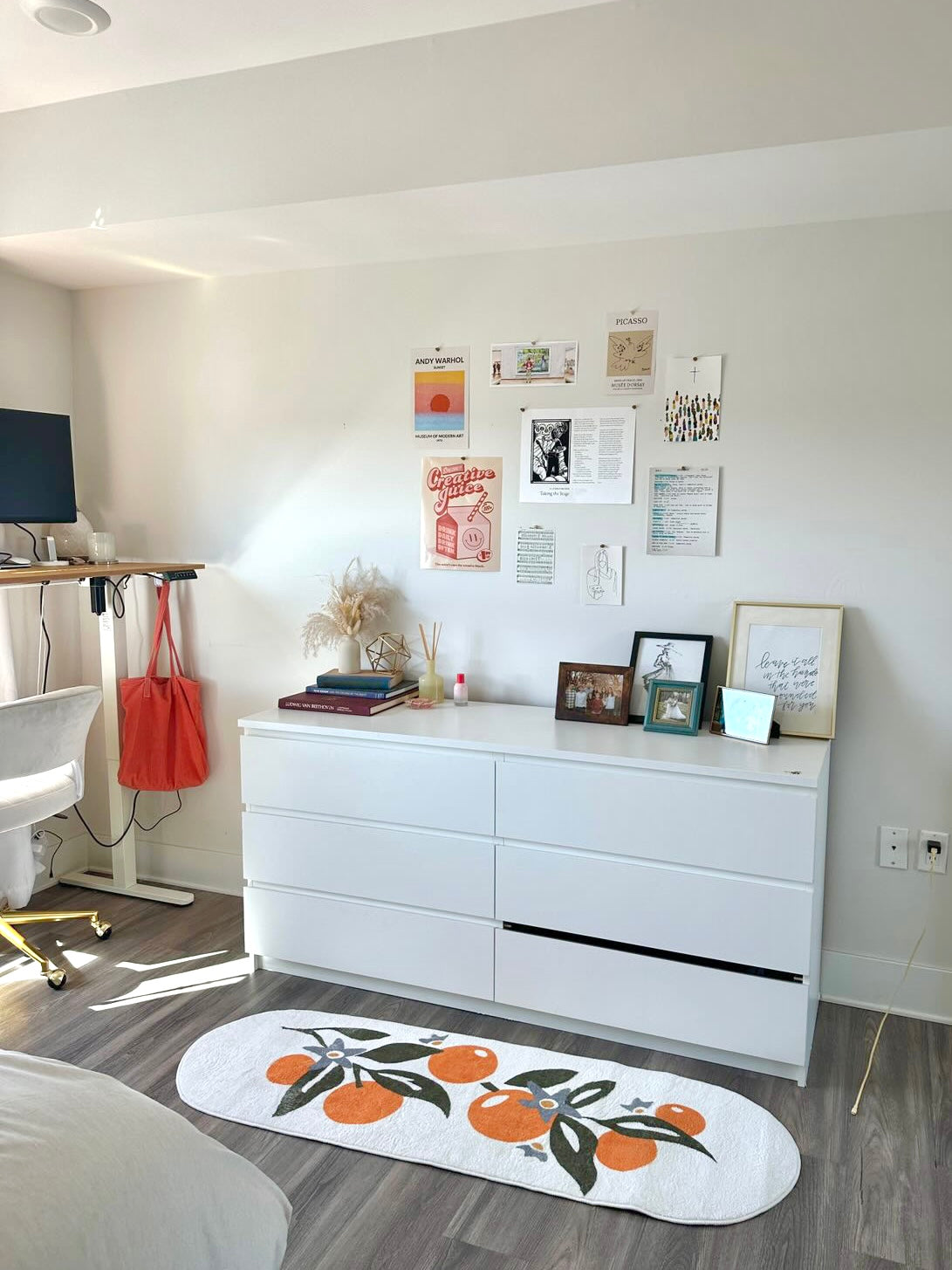 Orange Pattern Mat in a bright bedroom or office, laid in front of a white dresser with wall art above.