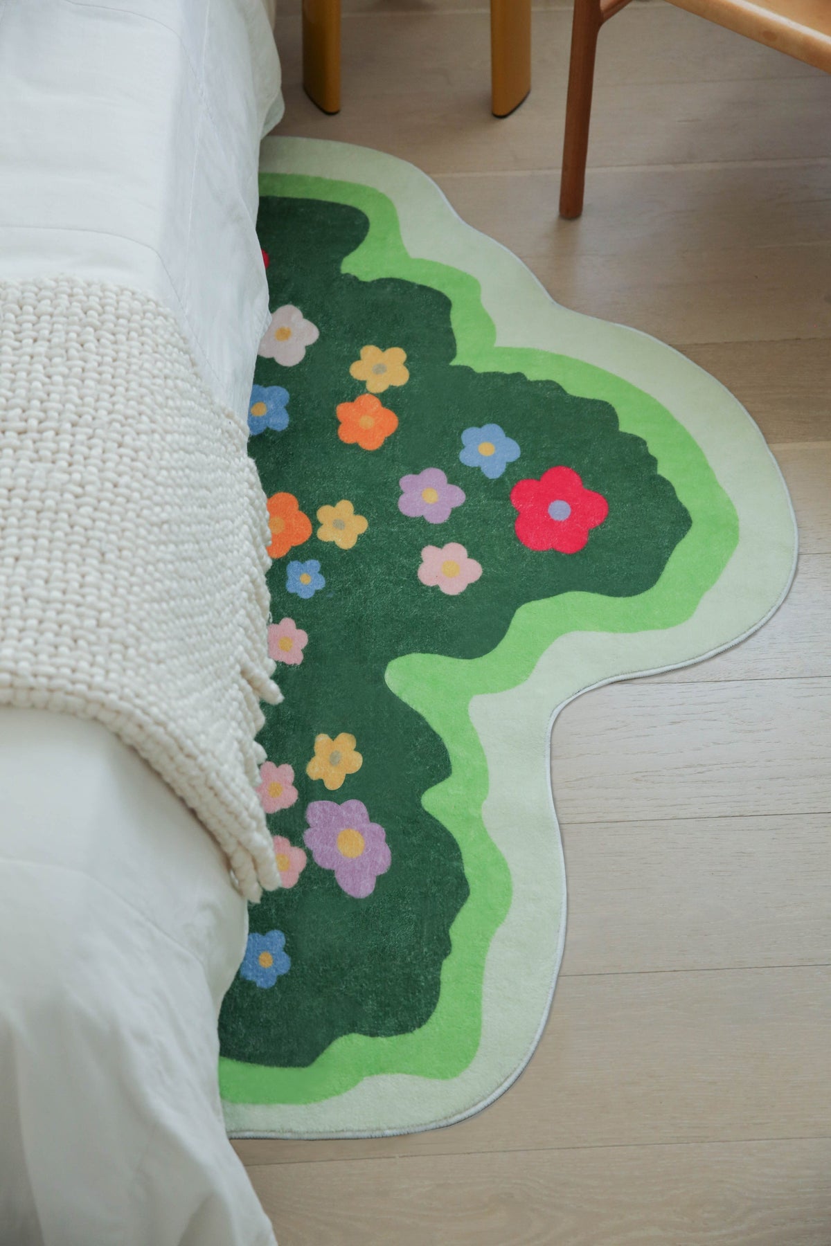Floral Irregular Runner placed beside a bed with a cream knit throw, partially tucked under the bedding.