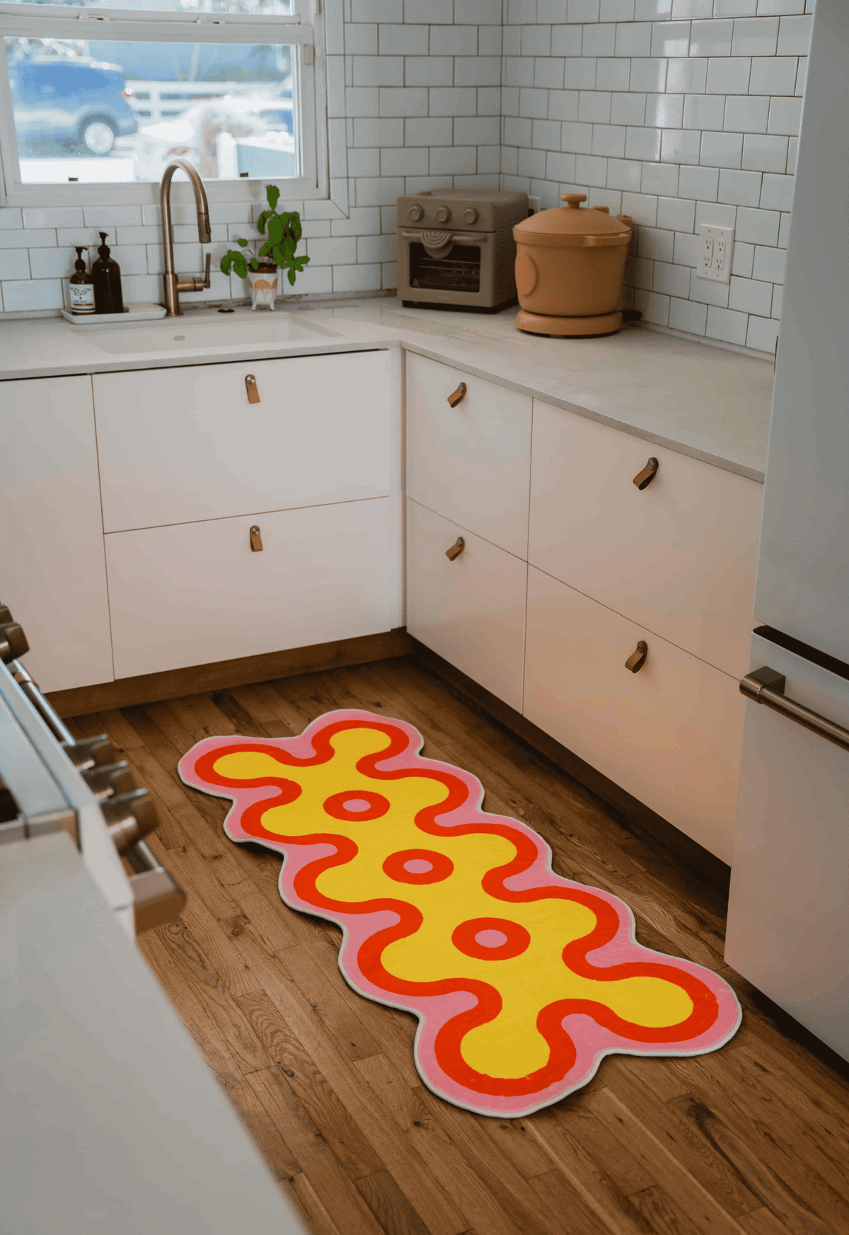 Irregular Coral Design Runner by Johann Banta on wooden floor in a modern kitchen corner with white cabinets and counter decor.