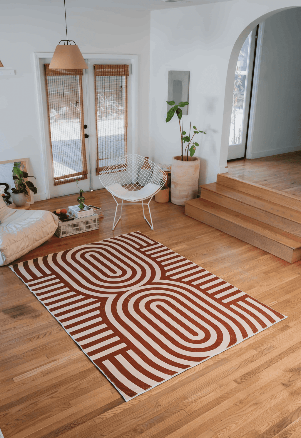 Wide view of the Curvy Brown Stripes Design Rug laid out in a bright living room, framed by modern furniture and arched doorway.