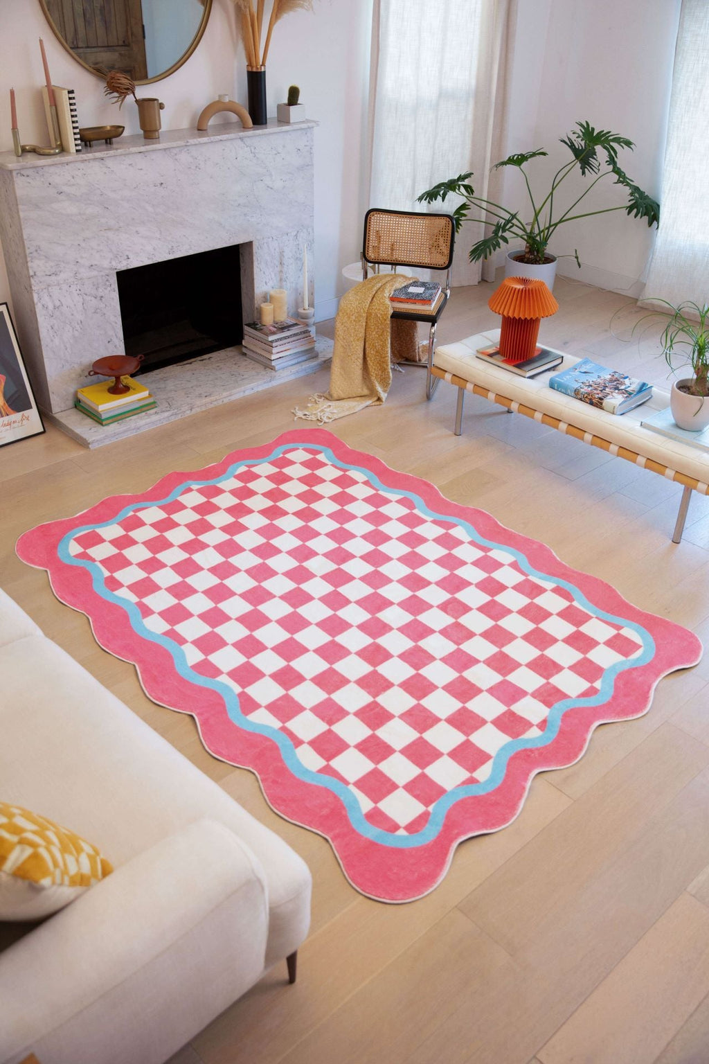 A living room styled with the Pink and Blue Lace Checkered Rug, featuring a pink checkerboard center with wavy blue and pink trim.