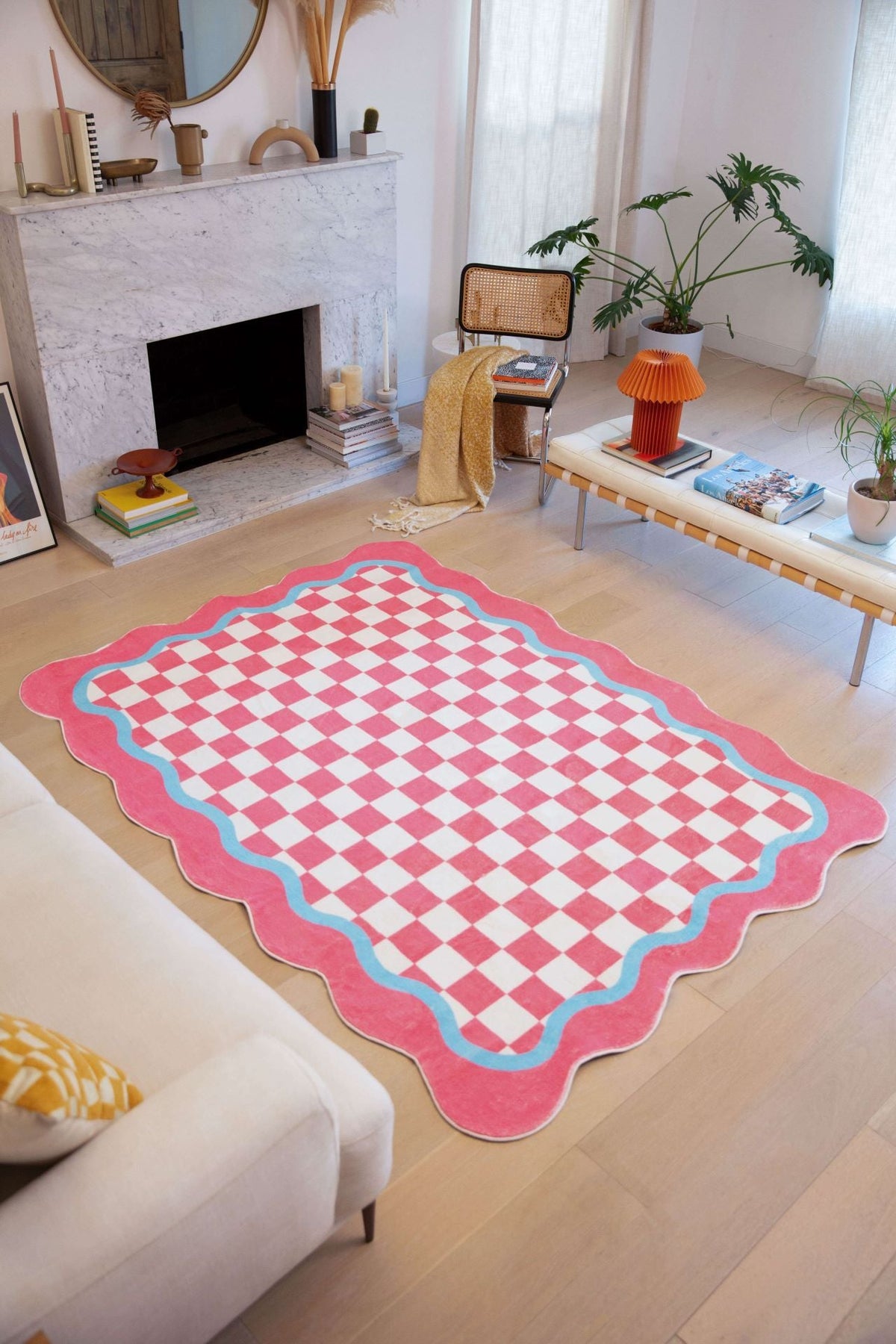 A living room styled with the Pink and Blue Lace Checkered Rug, featuring a pink checkerboard center with wavy blue and pink trim.
