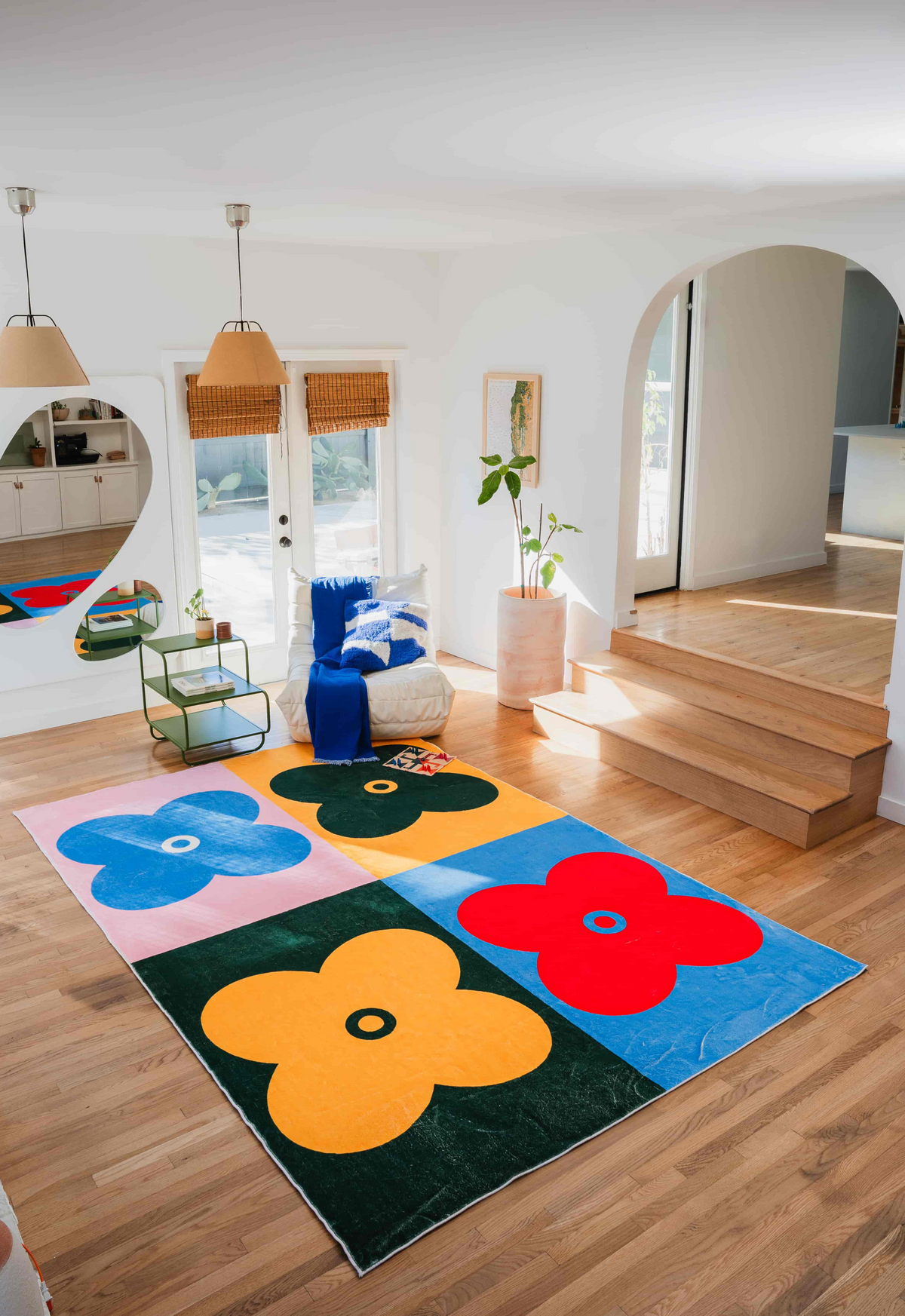 Multicolor four-leaf clover rug in modern living room, paired with bean bag, mirror, and glass coffee table for a cozy vibe.