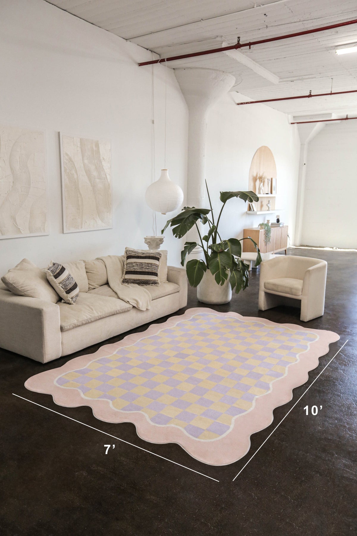 Wider angle of the same rug in a 7'x10' layout, highlighting its scalloped edges and pastel color palette in a spacious interior.