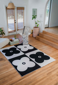 Black and white version of the four leaf clover rug styled with monochrome decor and a patterned throw.