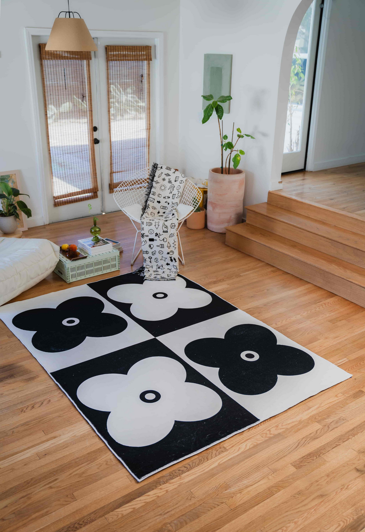 Black and white version of the four leaf clover rug styled with monochrome decor and a patterned throw.