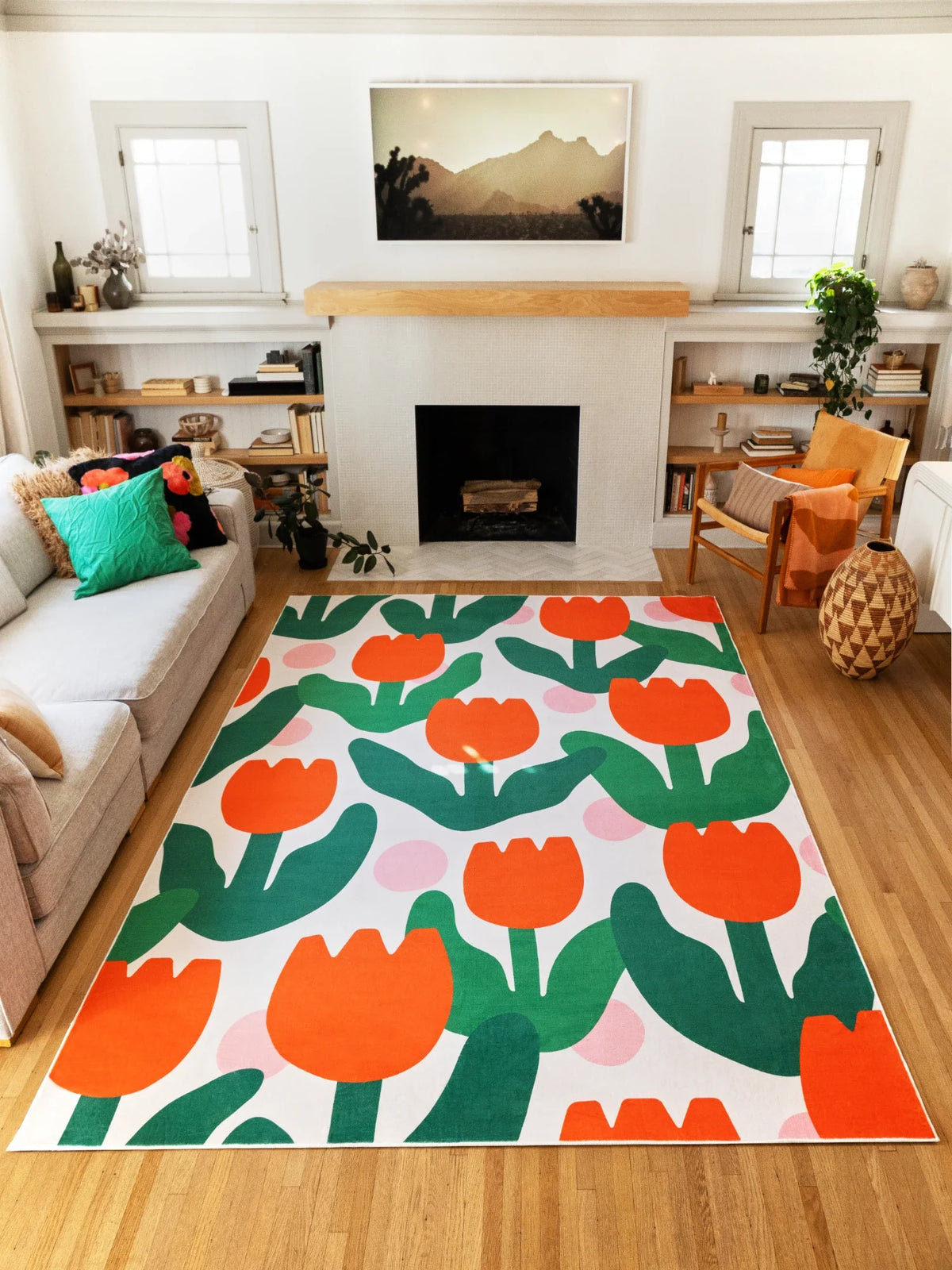Graphic floral rug in front of the fireplace, showing rows of orange tulip motifs and broad green leaves