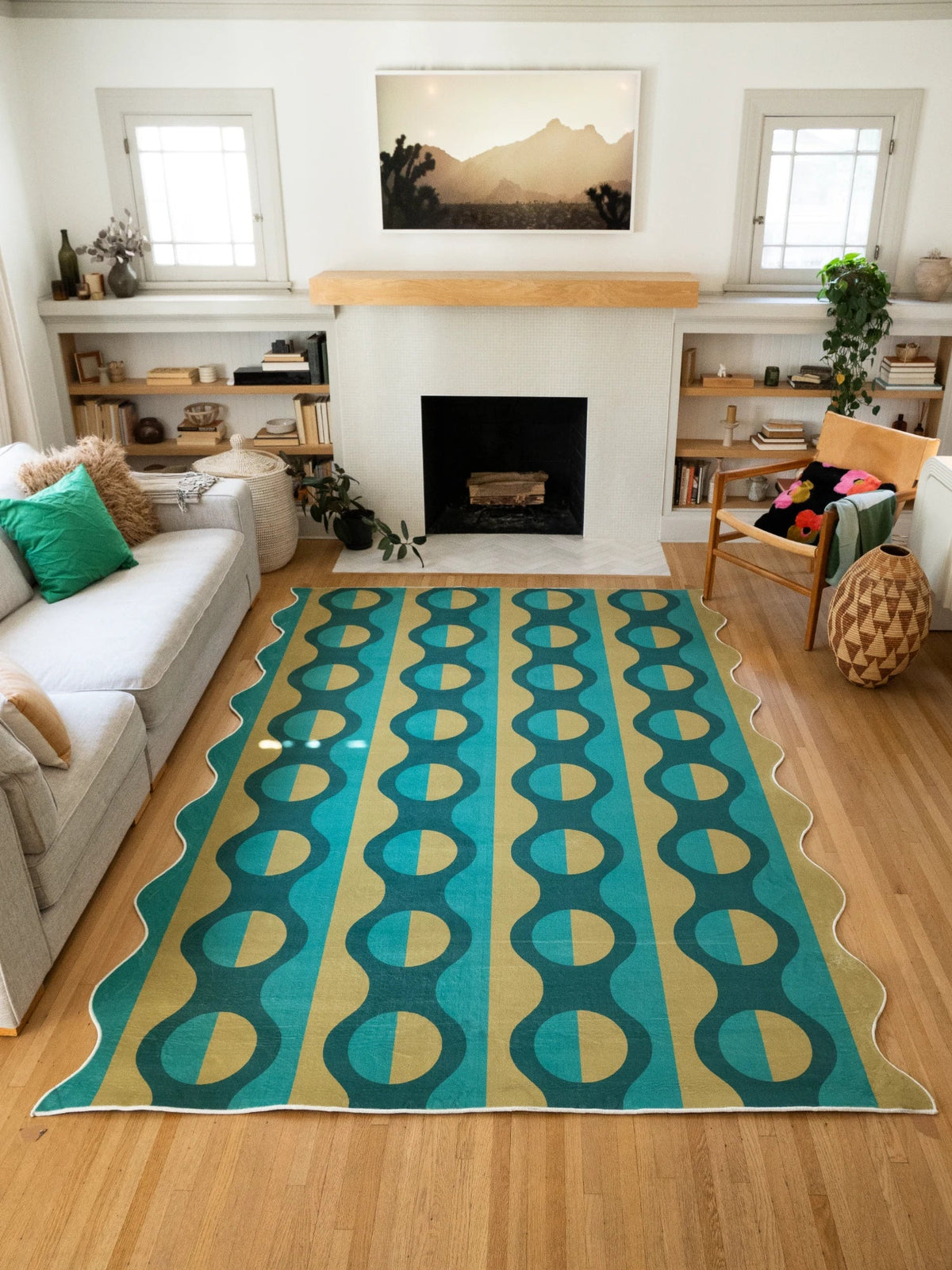Green geometric striped rug in a bright living room, with mustard oval motifs leading toward the fireplace