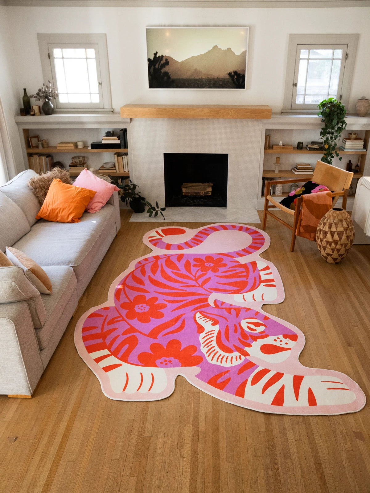 Pink vintage tiger shaped rug laid in front of the fireplace, with coral stripes and a crouching tiger silhouette