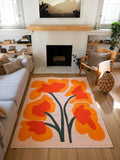Orange Abstract Floral Sprig Rug by Sophie Deller in a sunlit living room with a fireplace, sofa, and wood chair