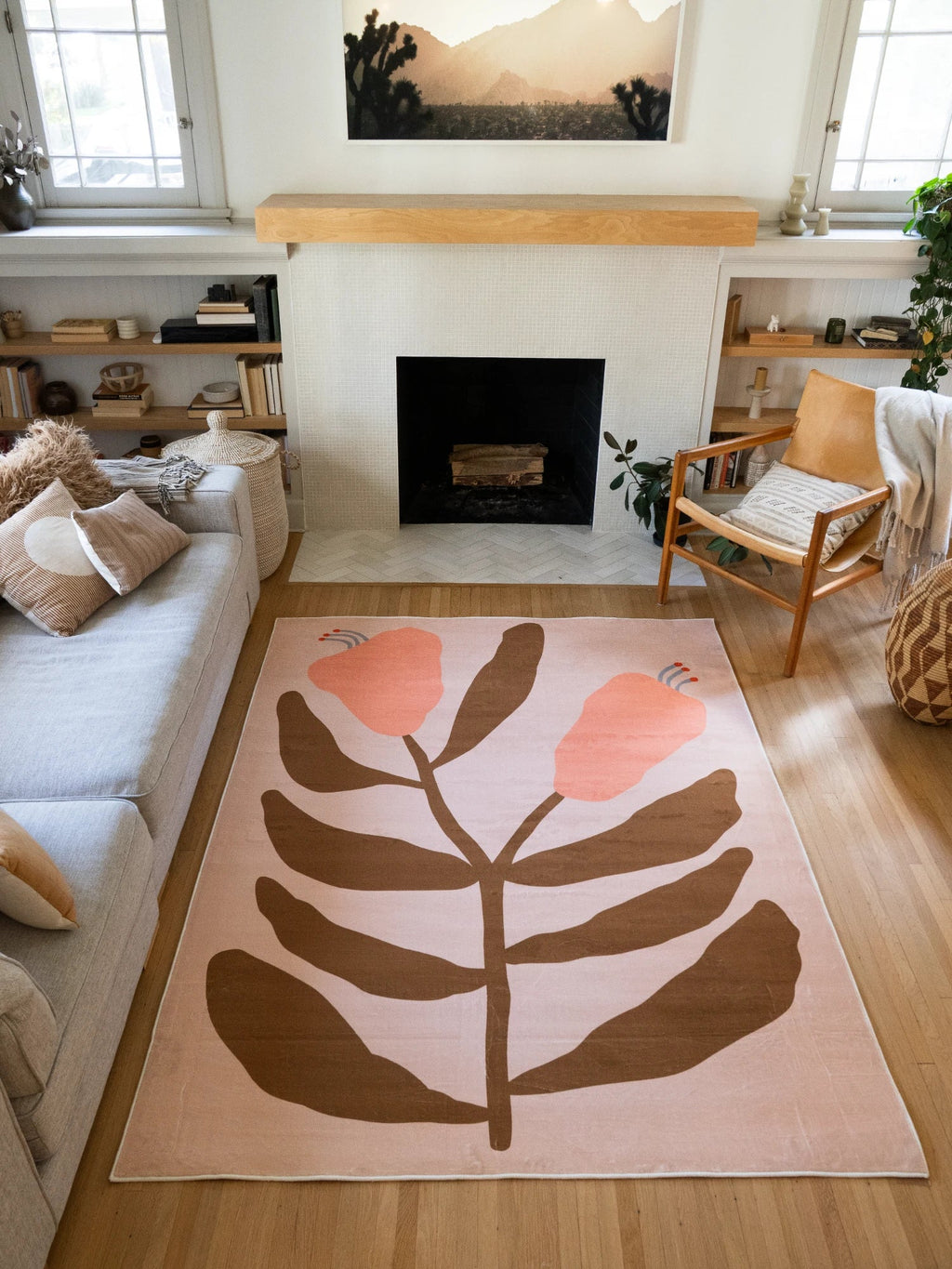Beige Vintage Flower Rug by Sophie Deller in a sunlit living room with a fireplace, neutral sofa, and wood accent chair