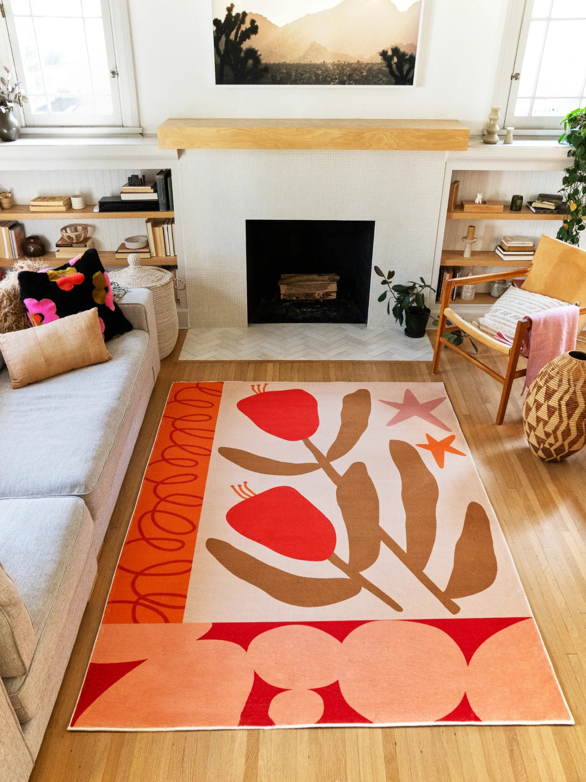 Wide room view of the floral abstract rug placed between the sofa and fireplace on a light wood floor