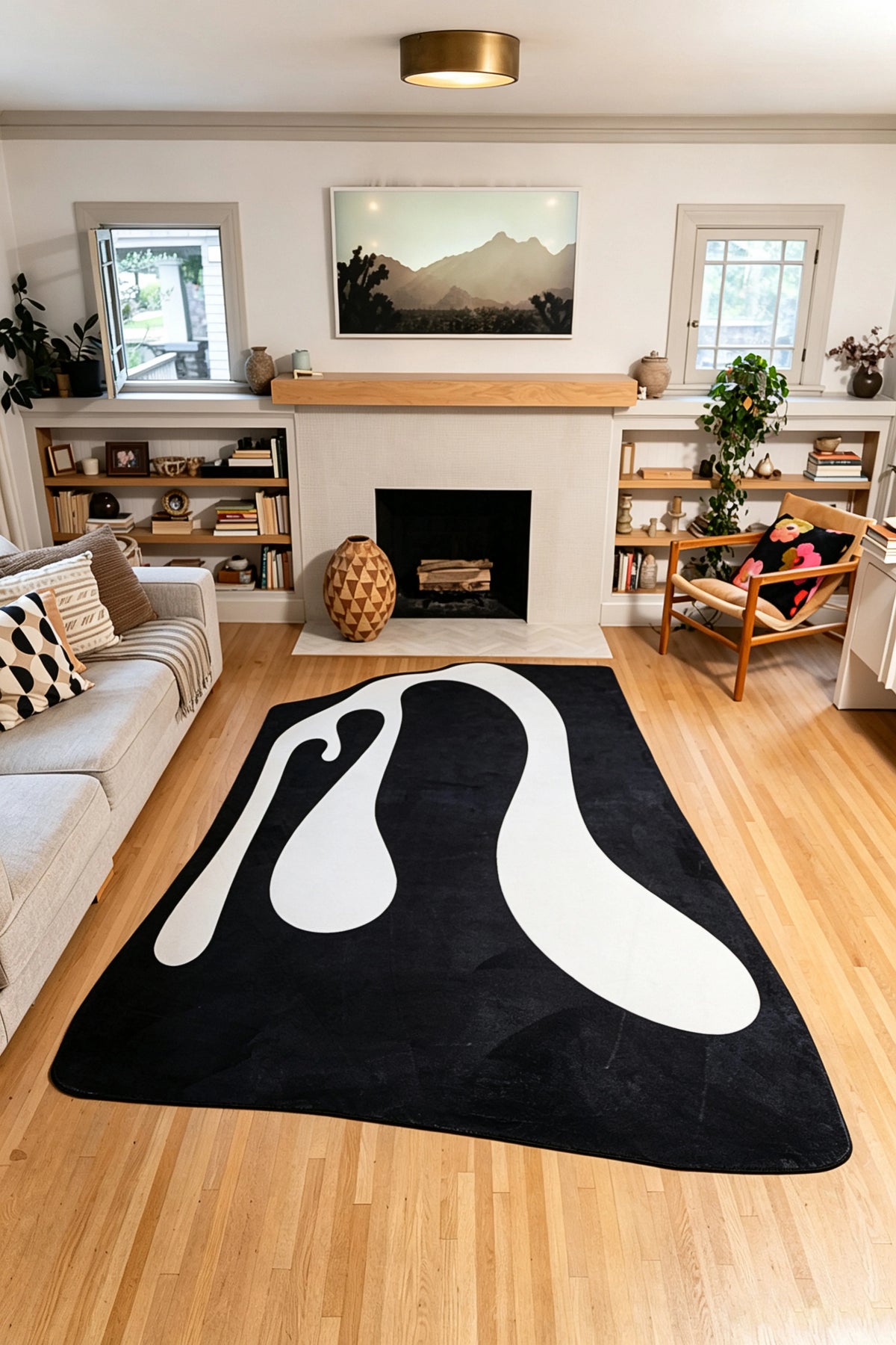 A 7' × 10' Flowing Ribbon Abstract Rug by Ariana Berman spreads across the living room, framed by a gray sofa and wooden armchair.