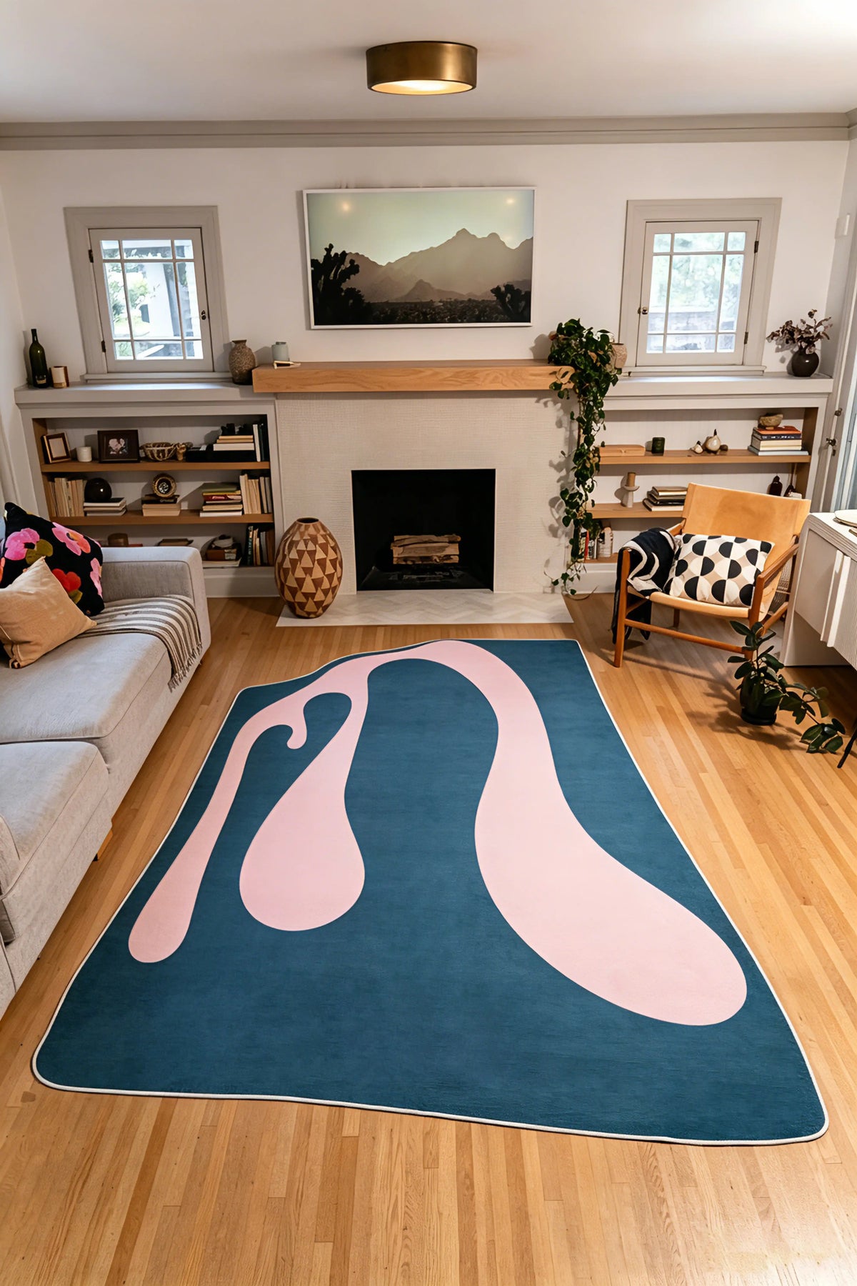 A pale pink ribbon sweeps across the 7' × 10' blue rug from the foreground toward the fireplace.