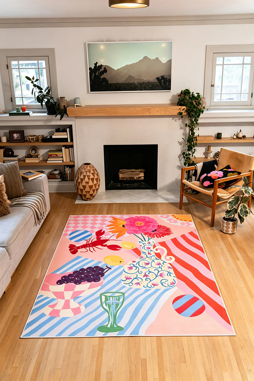 5' × 7' colorful rug with pink, red, and blue stripes, fruit, flowers, and a lobster centered in front of a fireplace.