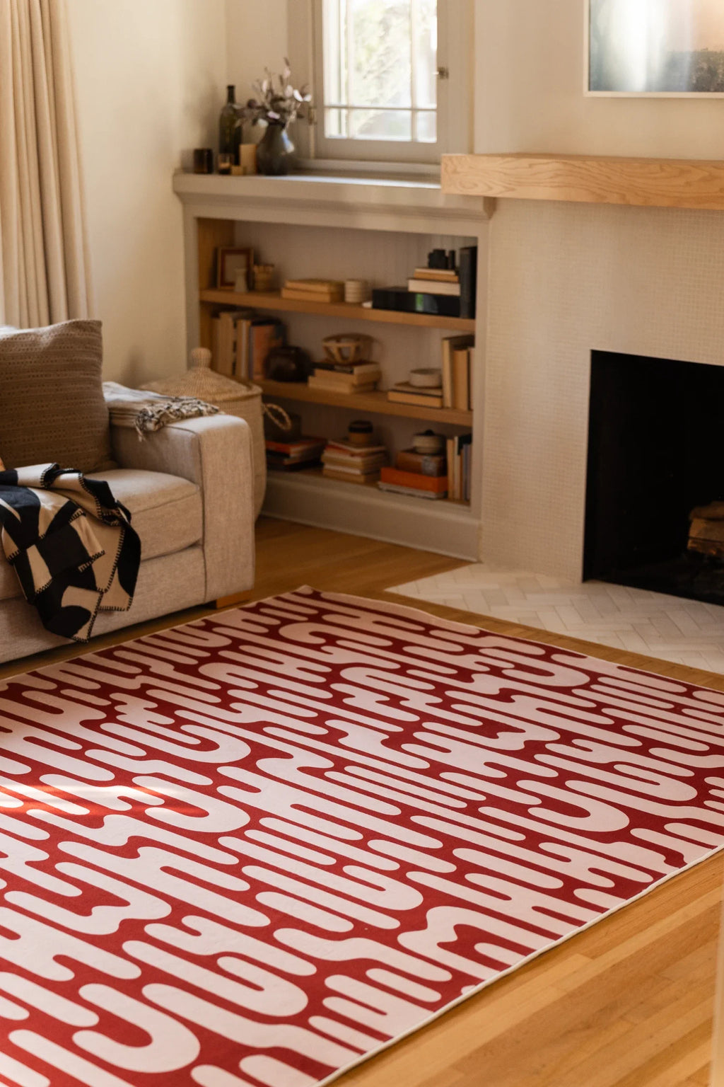 Brown Abstract Wavy Area Rug near a fireplace and open shelving in a soft toned modern interior