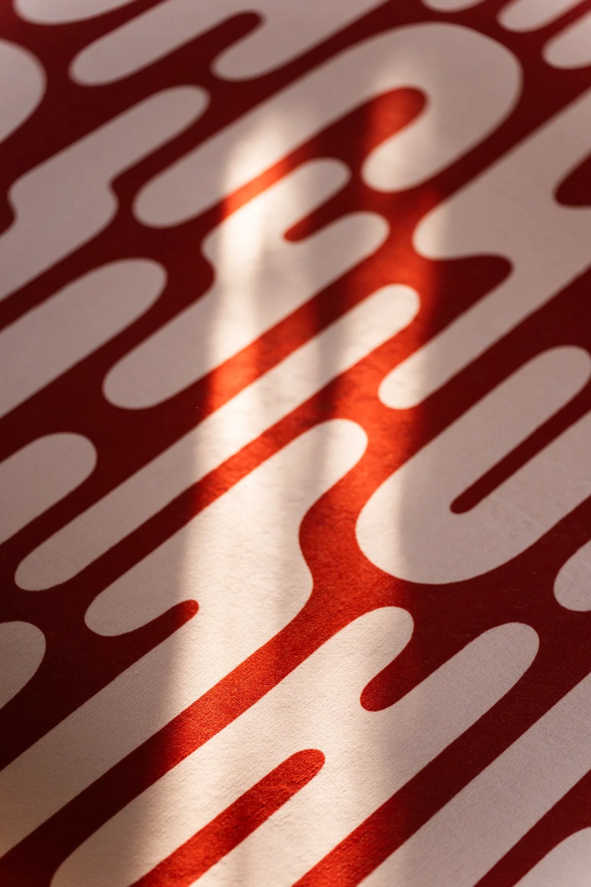 Close up of the brown Abstract Wavy Area Rug with flowing graphic bands and sunlight across the pattern