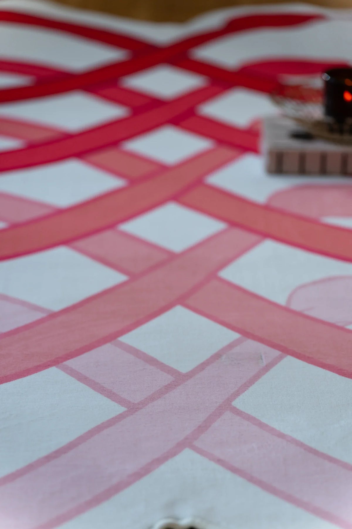 Detail of the abstract area rug showing dense red loops over white bands in a bold graphic layout