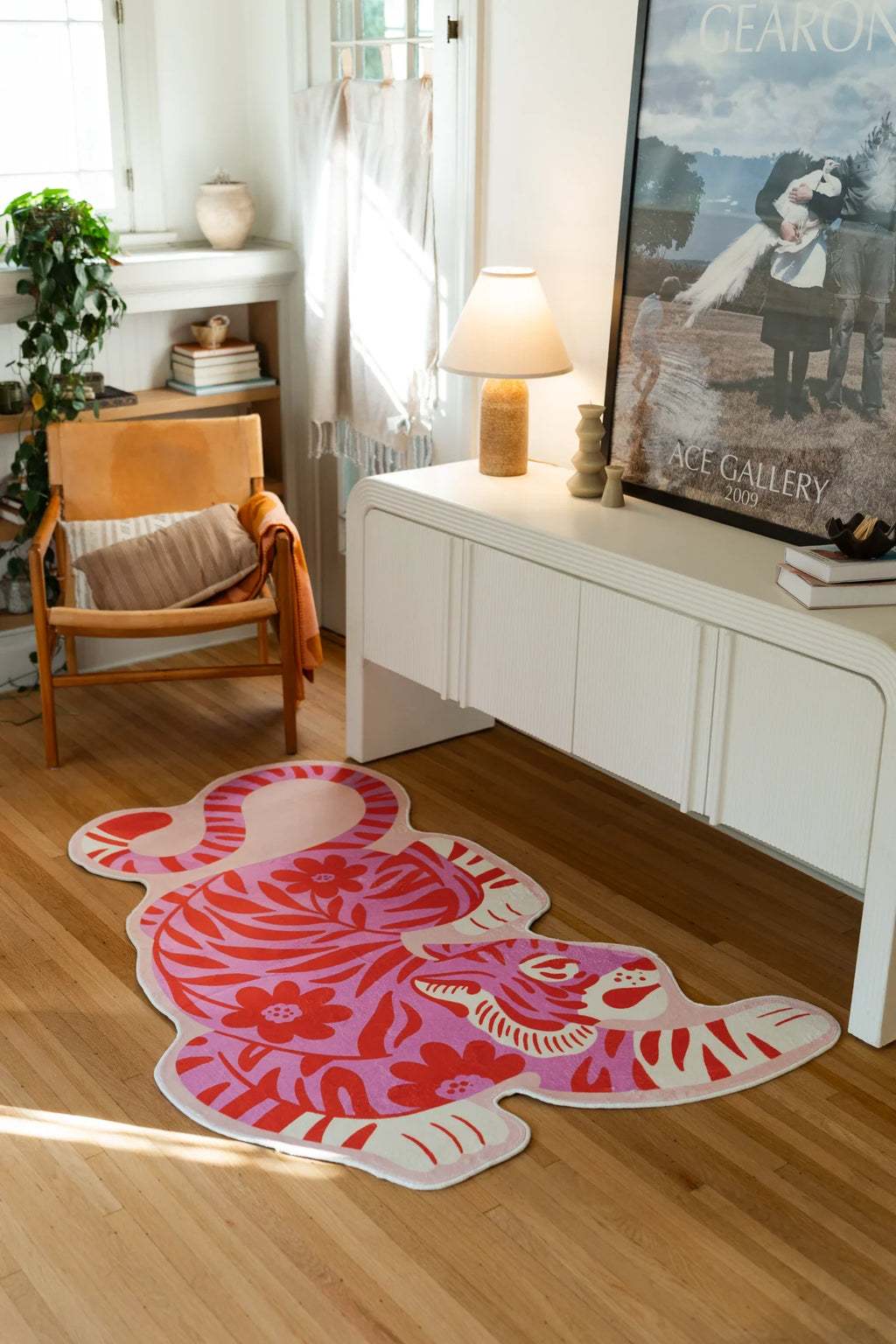 Pink tiger area rug beside a white media console and framed art in a creative living corner