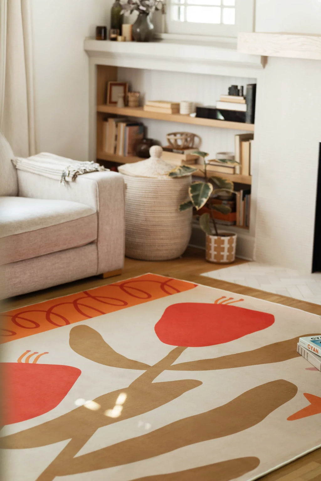Retro floral rug beside a beige sofa and open shelving, showing red flower forms and tan branching stems