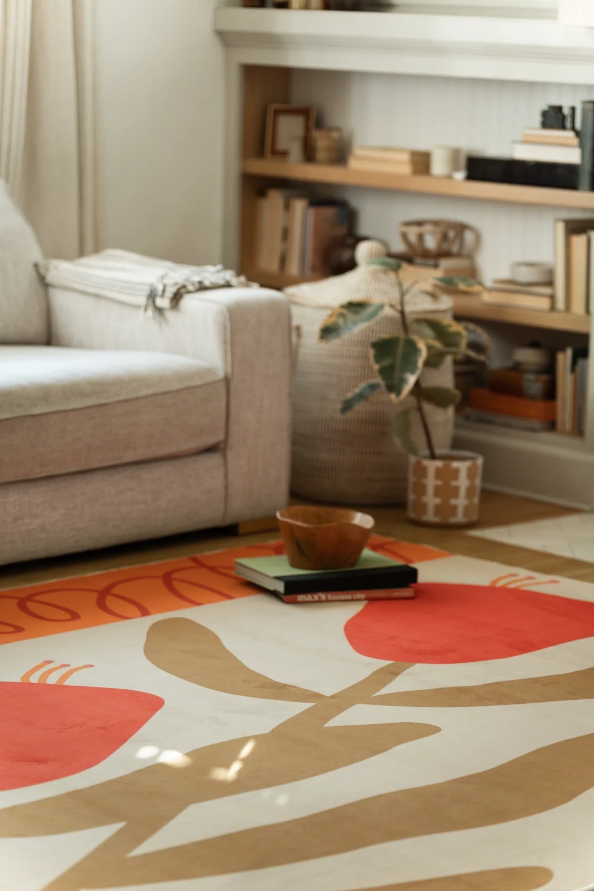 Partial view near the sofa and shelf, with rounded red petals and hand drawn stem shapes on a cream ground