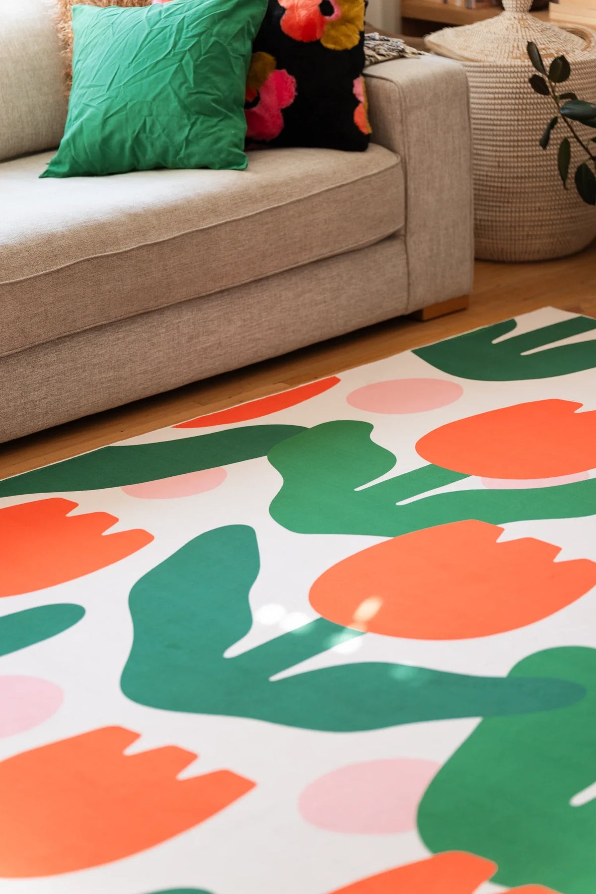 Close crop near the beige sofa, showing the repeating floral pattern and flowing green stems