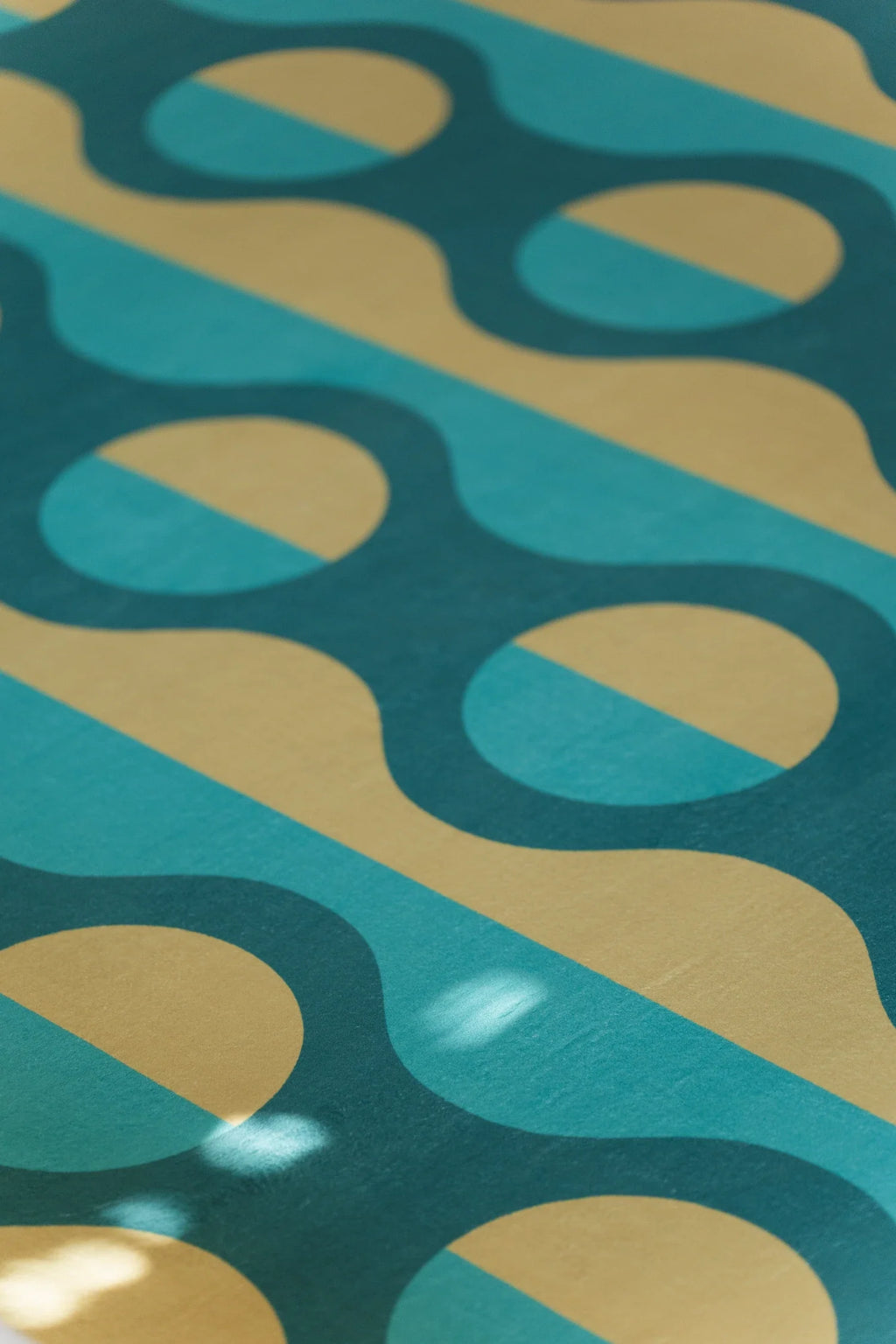 Detail of the modern geometric rug showing mustard ovals nested inside deep green vertical stripes
