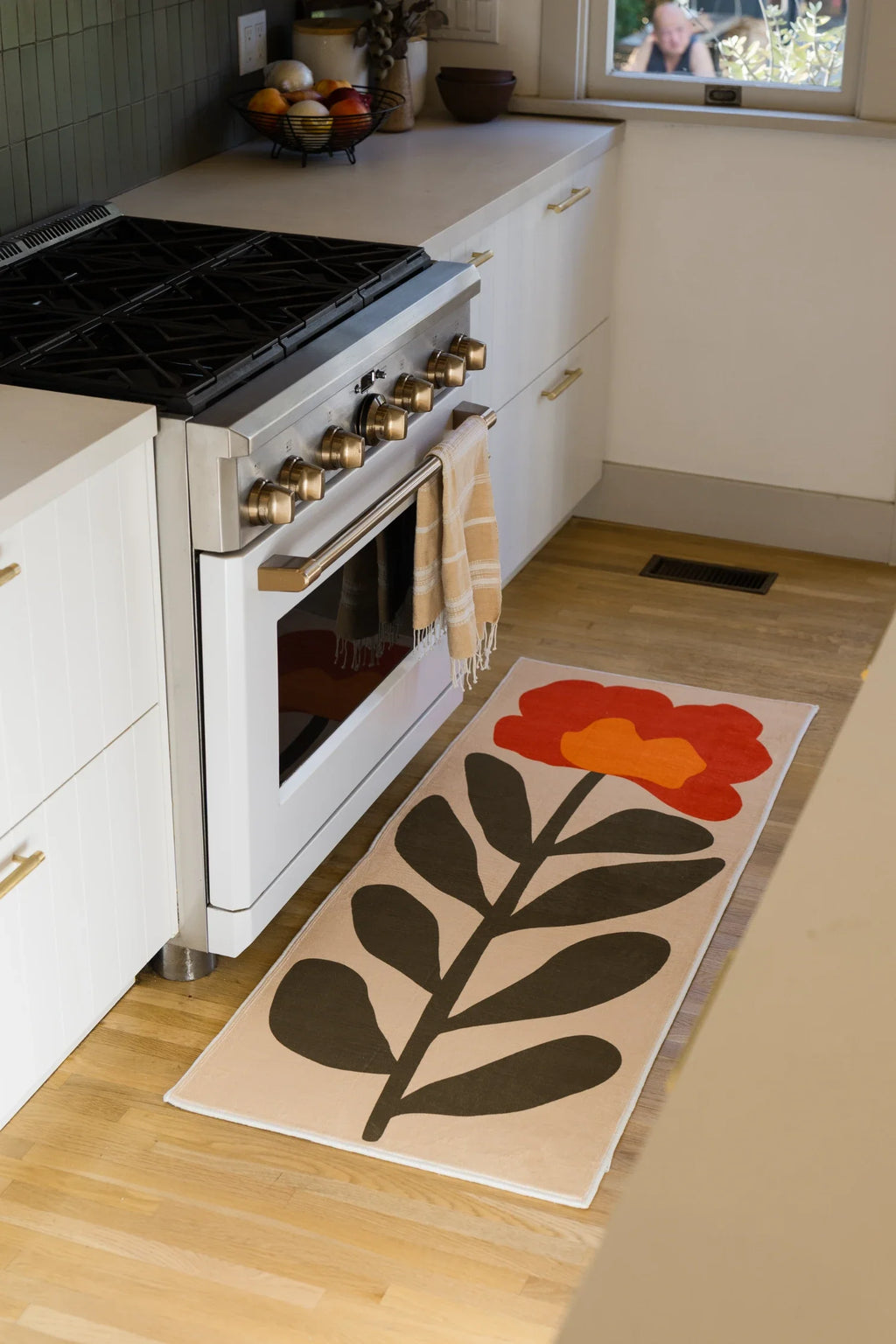 Red Vintage Flower Runner Rug by Sophie Deller beside a white kitchen oven on a light wood floor