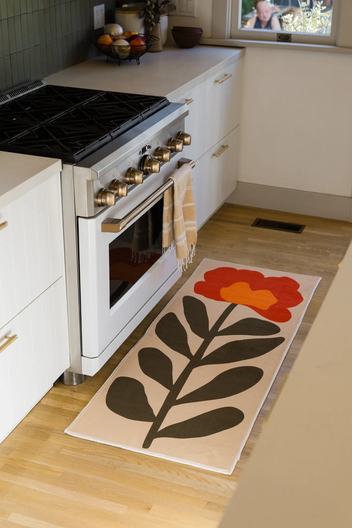Red Vintage Flower Runner Rug by Sophie Deller beside a white kitchen oven on a light wood floor