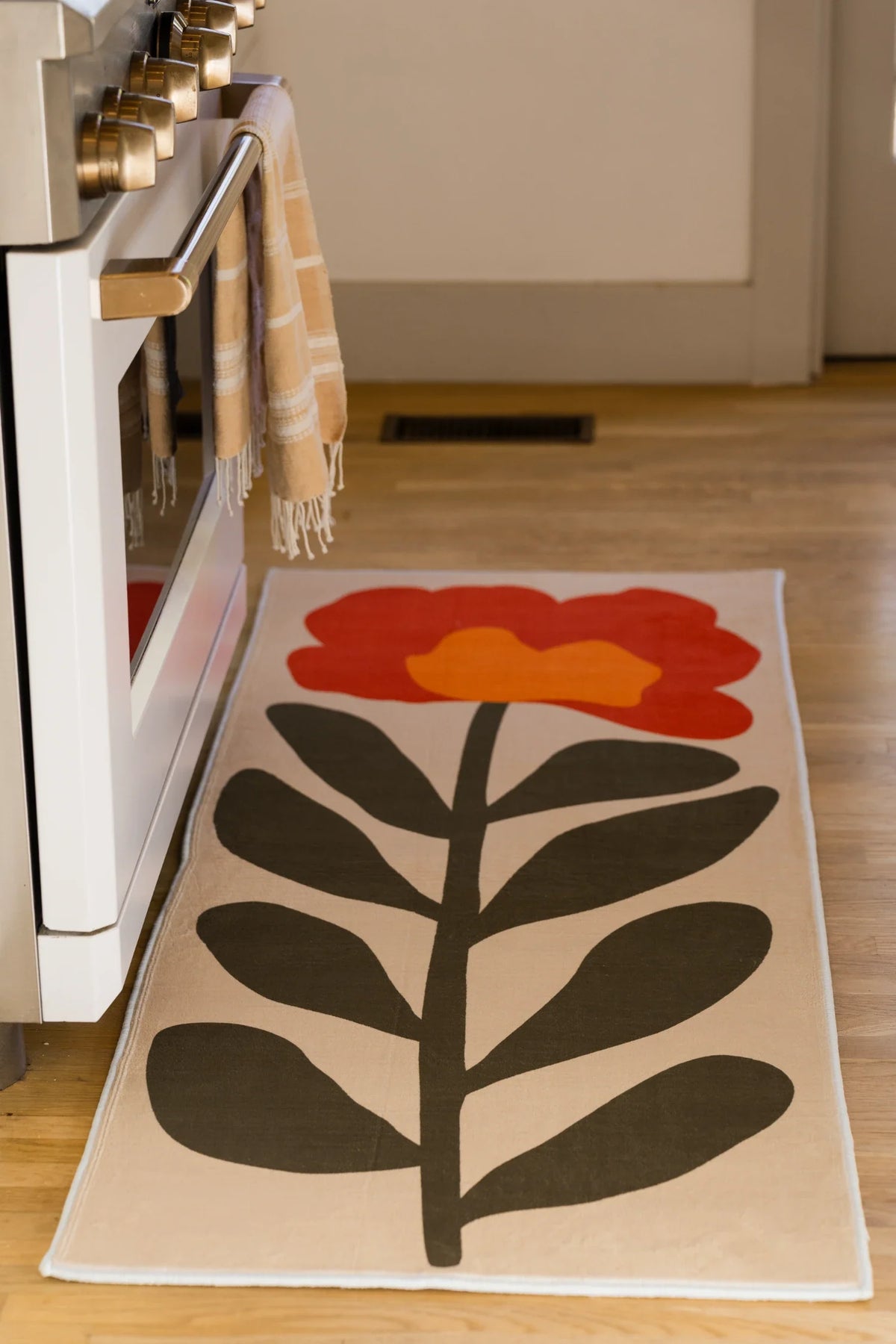Long crop of the runner near the oven, highlighting the single flower head and graphic leaf pattern
