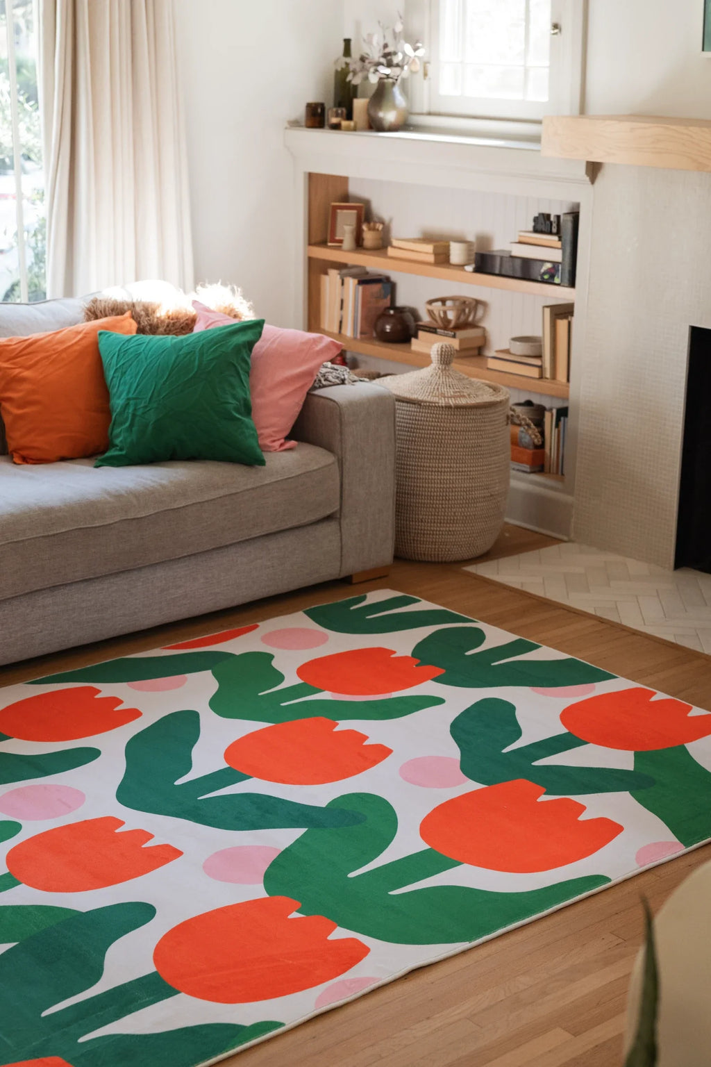 Modern floral area rug beside a beige sofa in a cozy living room, with oversized tulip forms and open shelving nearby