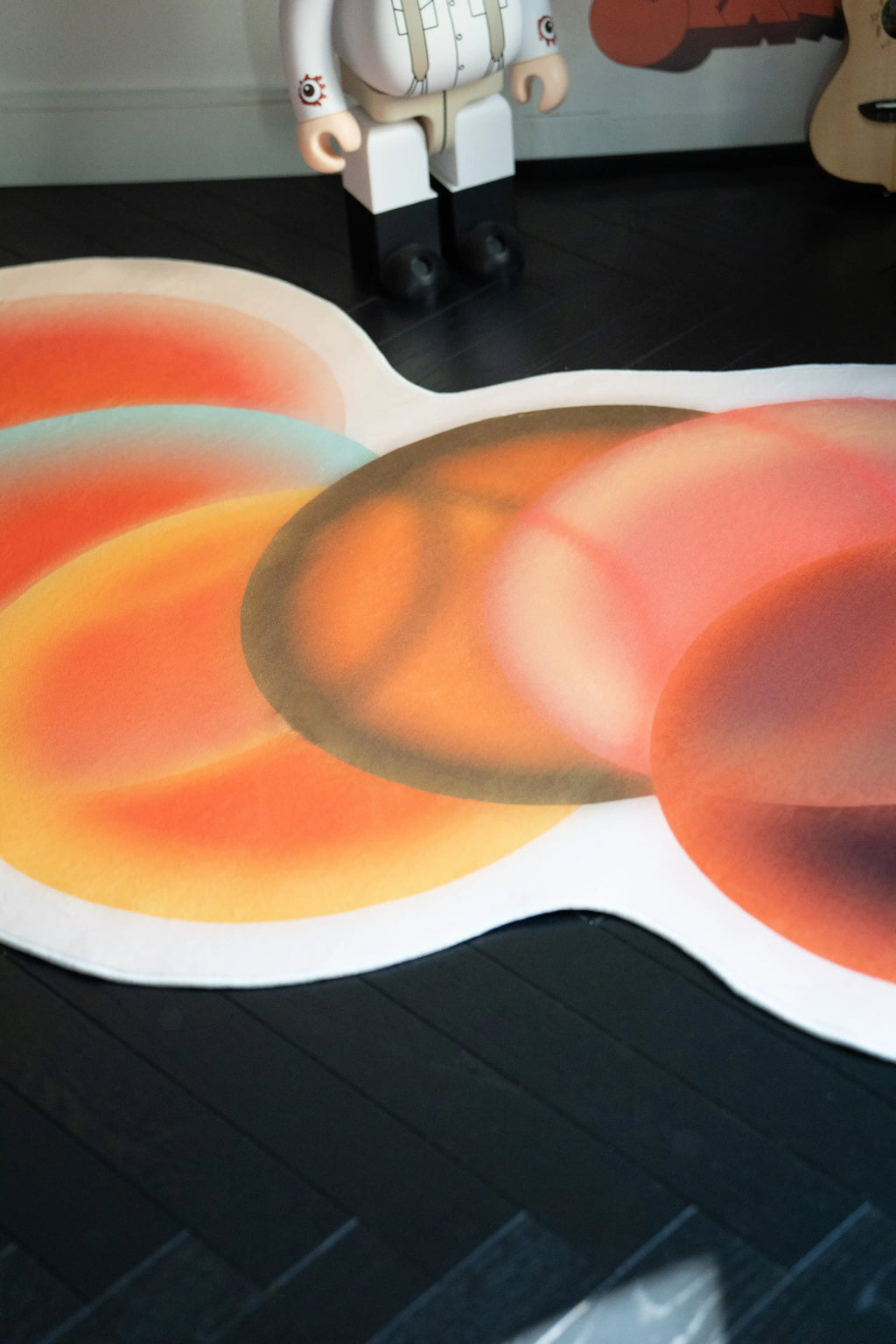 Close up of the abstract circle rug showing soft tonal rings in orange, rust, and deep brown