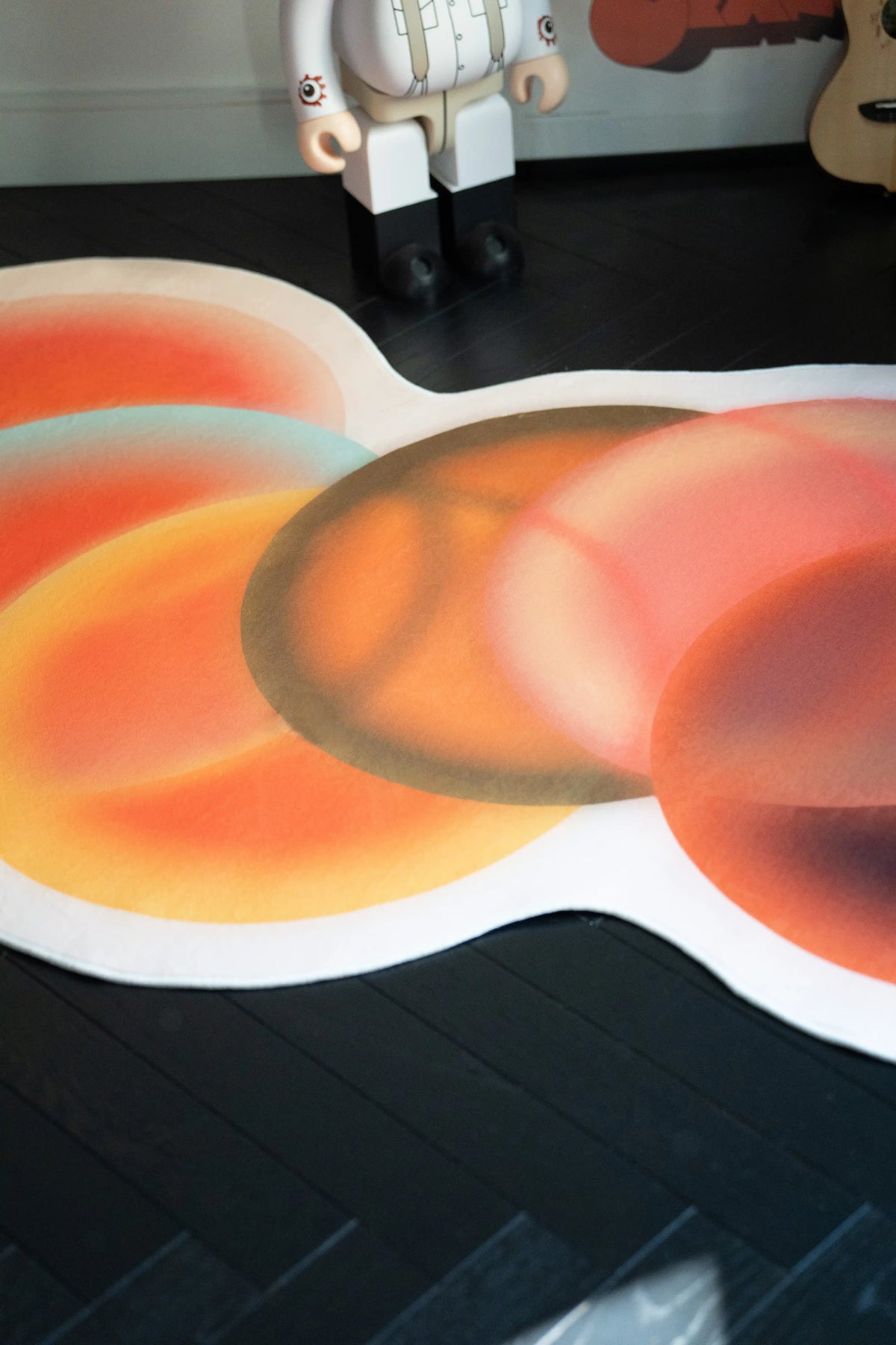 Close up of the abstract circle rug showing soft tonal rings in orange, rust, and deep brown
