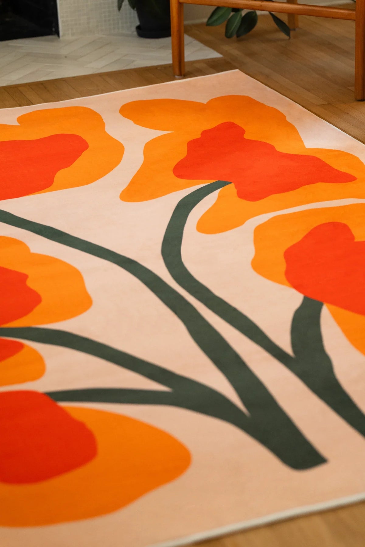 Close up of the Orange Abstract Floral Sprig Rug with branching stems and oversized orange blooms on a cream field