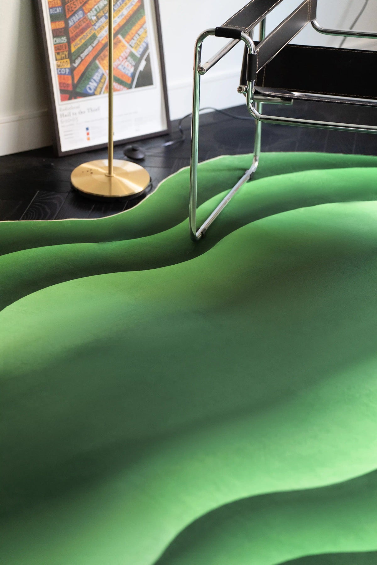 Green Modern Abstract Wavy Rug under a chrome chair in a modern corner with a floor lamp and framed print