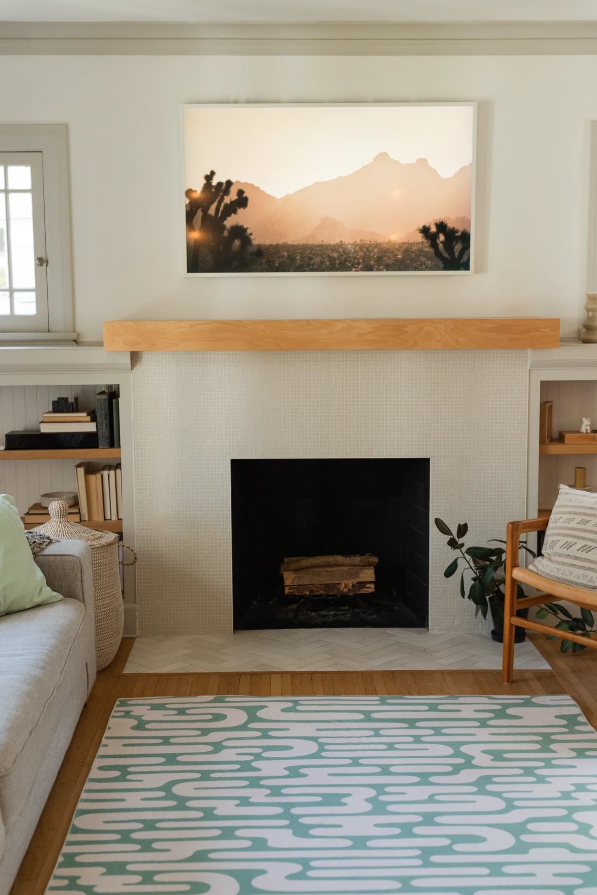 Green Abstract Wavy Area Rug stretching through an airy living room toward a fireplace and open shelving