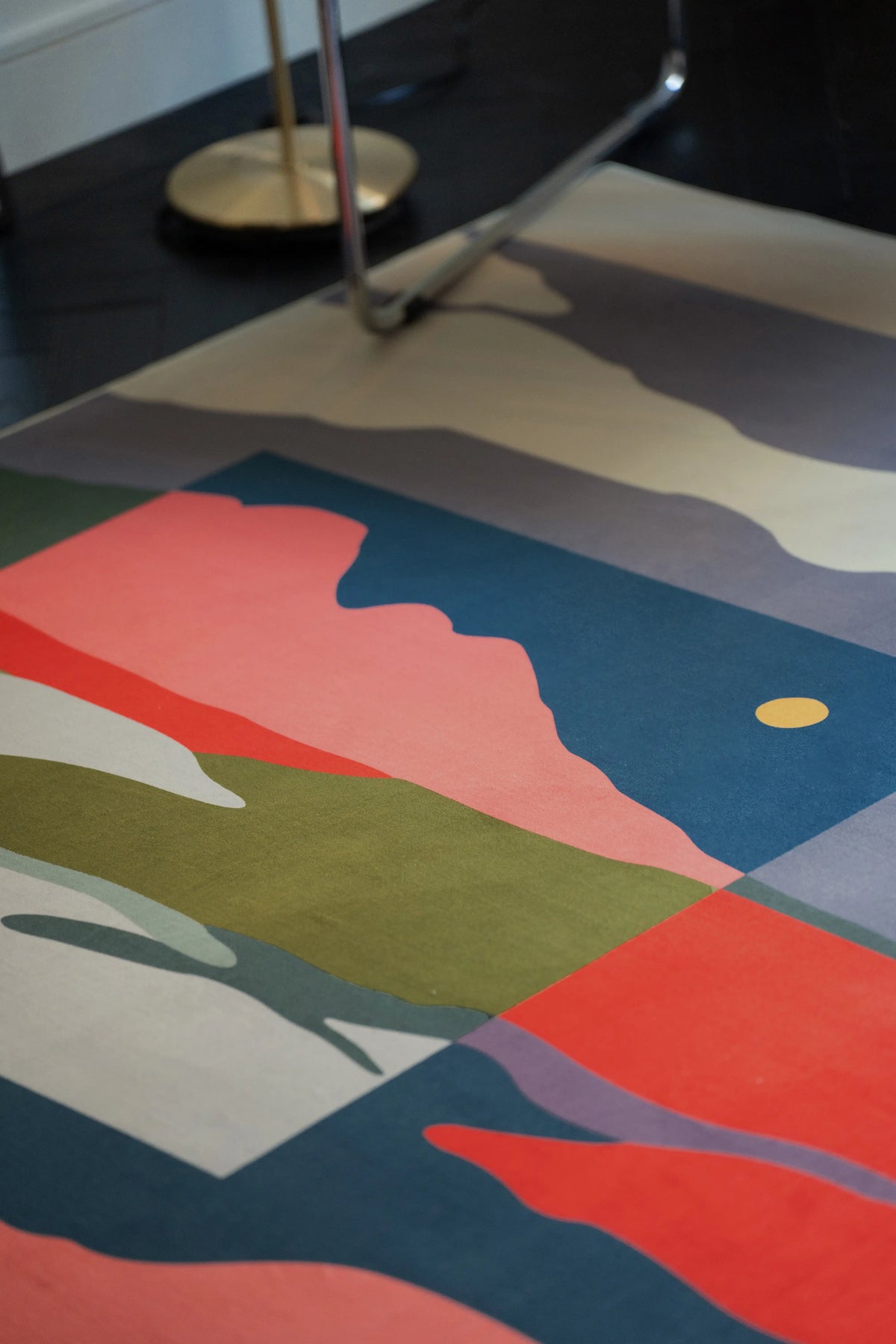 Close up of the Vintage Landscape rug showing cream cloud shapes, blue ground, coral forms, and an olive band