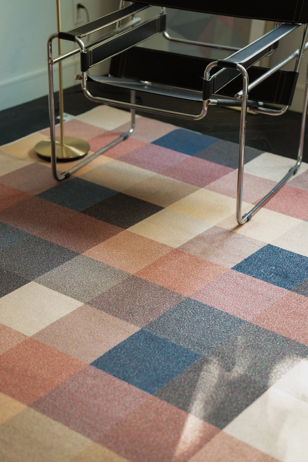 Earthy Brown Vintage Checkered Rug beneath a chrome chair showing brown, rust, blue, and beige color blocks