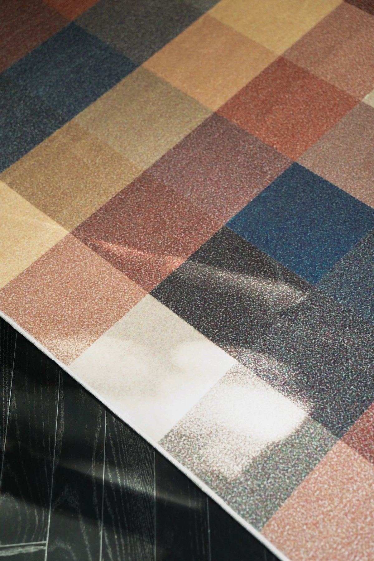 Corner close up of the Earthy Brown Vintage rug with blue and rust blocks and sunlight on the surface